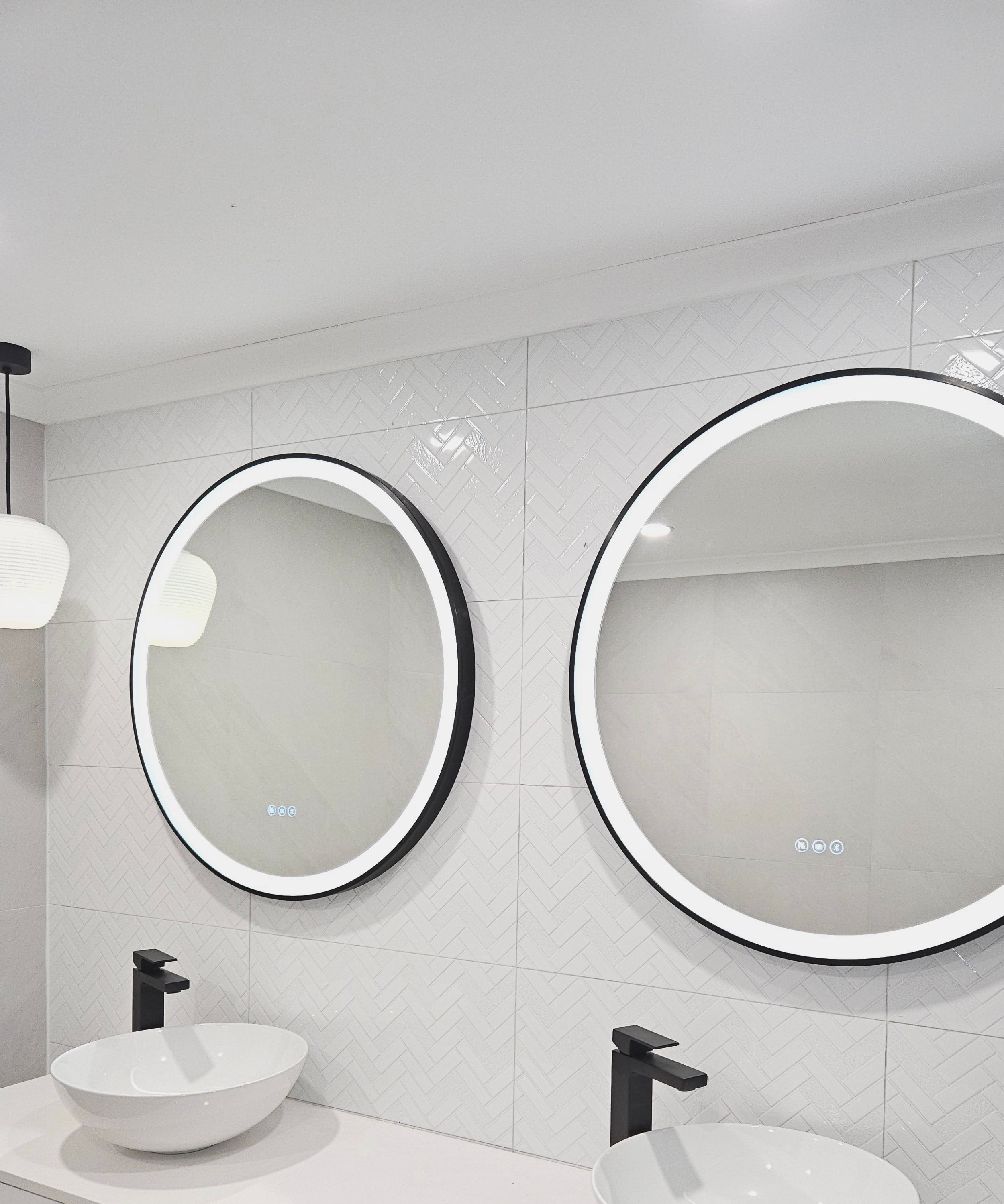 Dual Smart LED mirrors with black frames in an All-White bathroom with Black Contrasting Accents