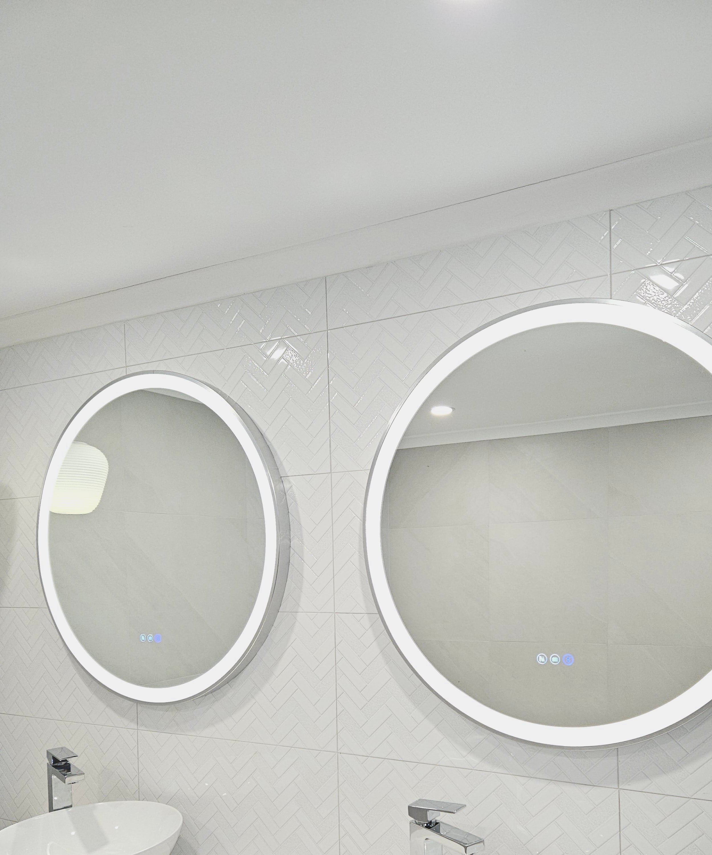 Doorway View of Two Silver Frame Circle Smart LED Mirrors in Couple's White-on-White Bathroom