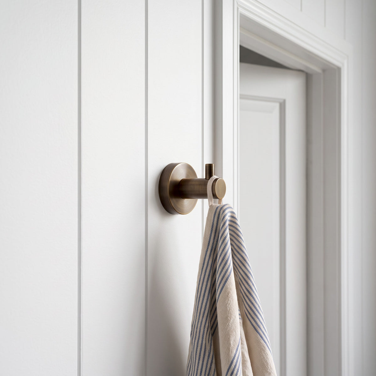 Copenhagen Robe Hook in Antique Brass in a bathroom