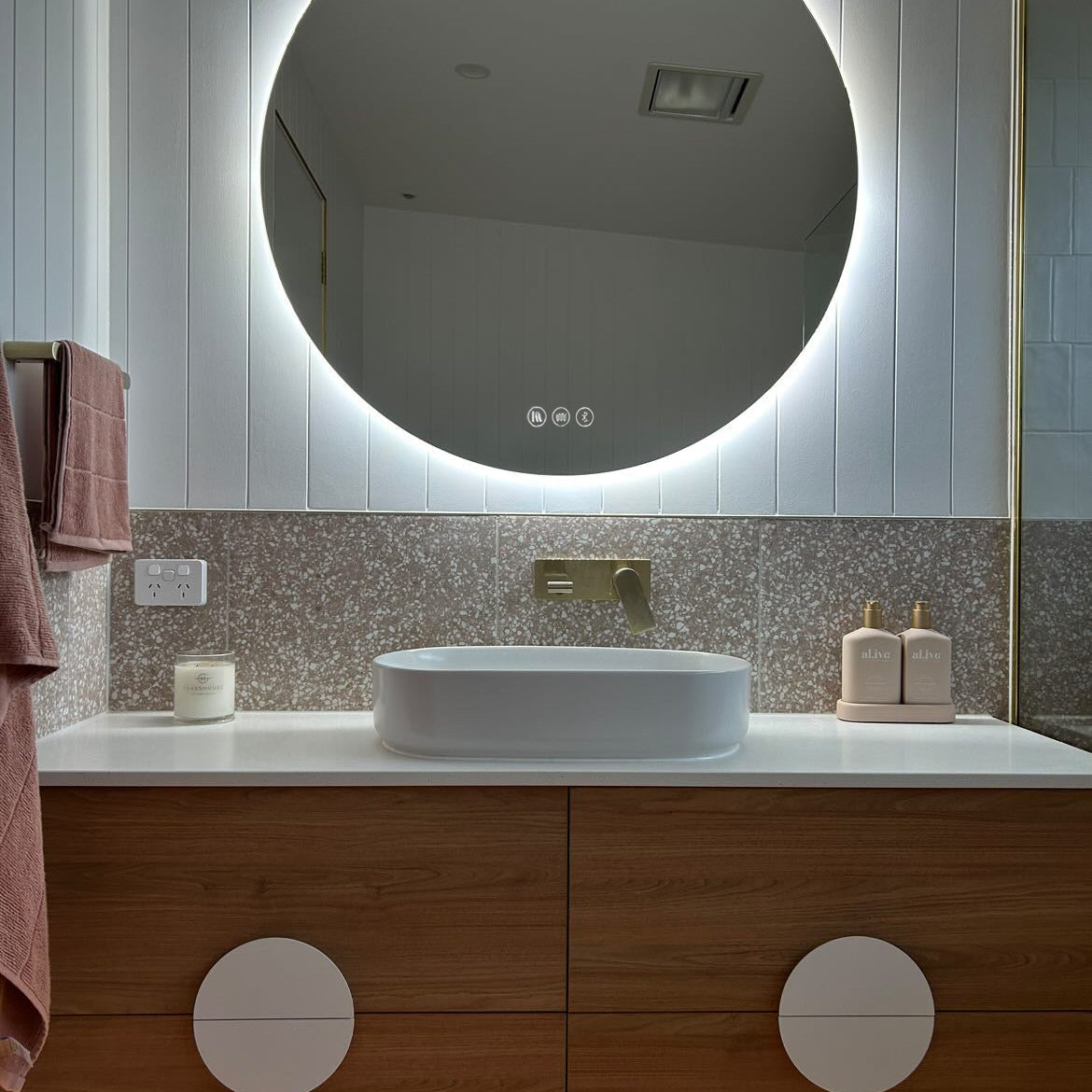 Versatile Circle Backlit LED Mirror in white, light brown, and gold themed bathroom.