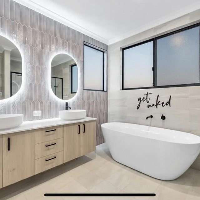 Dual oval Smart LED mirrors in couple's split-design bathroom with cabinet and freestanding bathtub