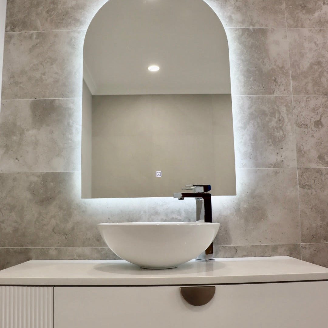 Glowing Backlit LED Mirror on Greyish-Brown Wall with Dirty White Vanity Cabinet and Vessel Sink