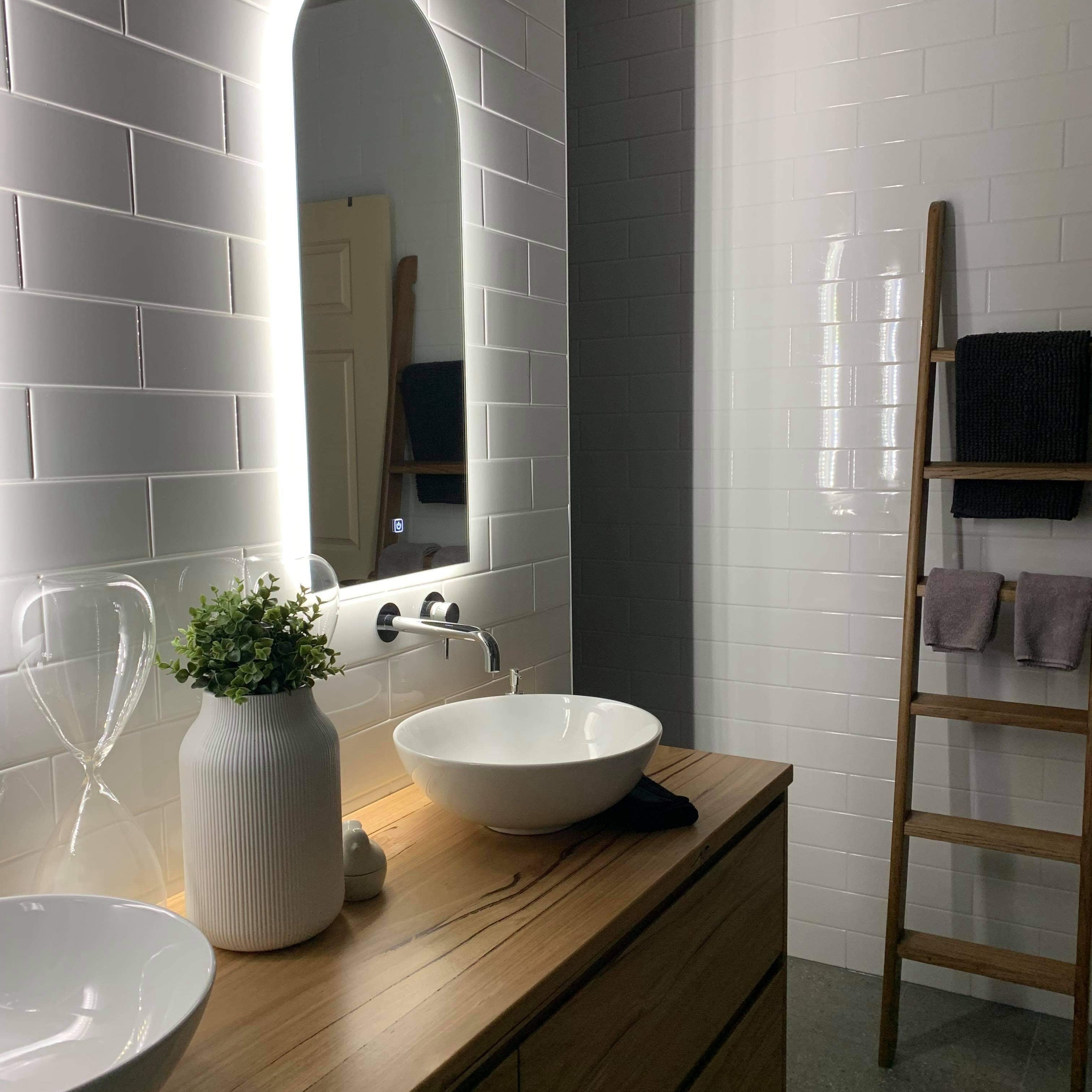 Right LED Foyer Mirror in Couple's Bathroom, Mounted on White Subway Tiles