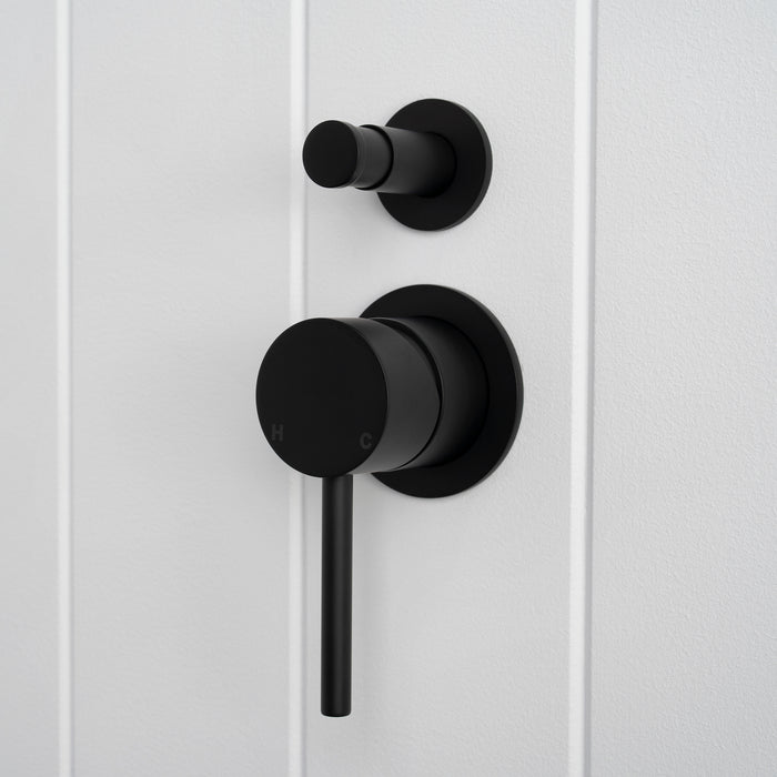 Cannes Shower Diverter and Mixer in Matte Black, three-quarter view of diverter and lever, white vertical-panelled wall
