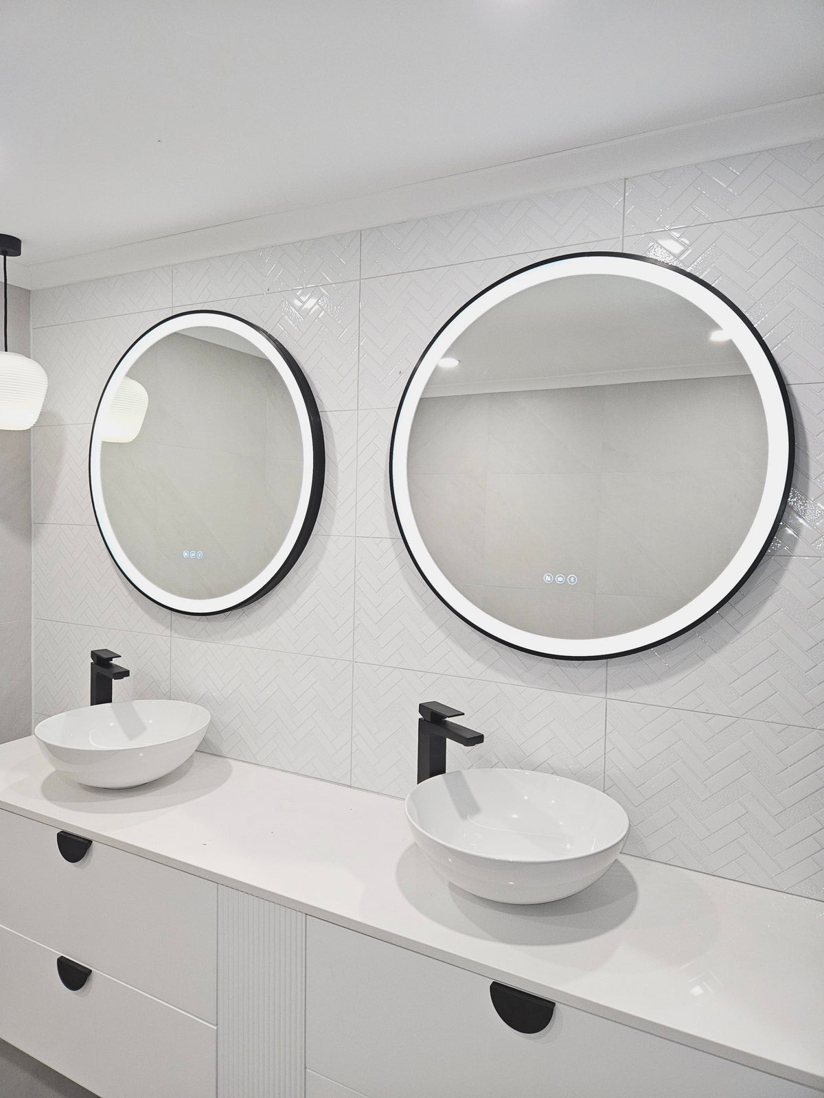 Dual Smart LED mirrors with black frames in an All-White bathroom with Black Contrasting Accents