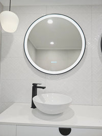 Smart Circle Black Frame LED Mirror on the Left Side in White Powder Room with Black Accents