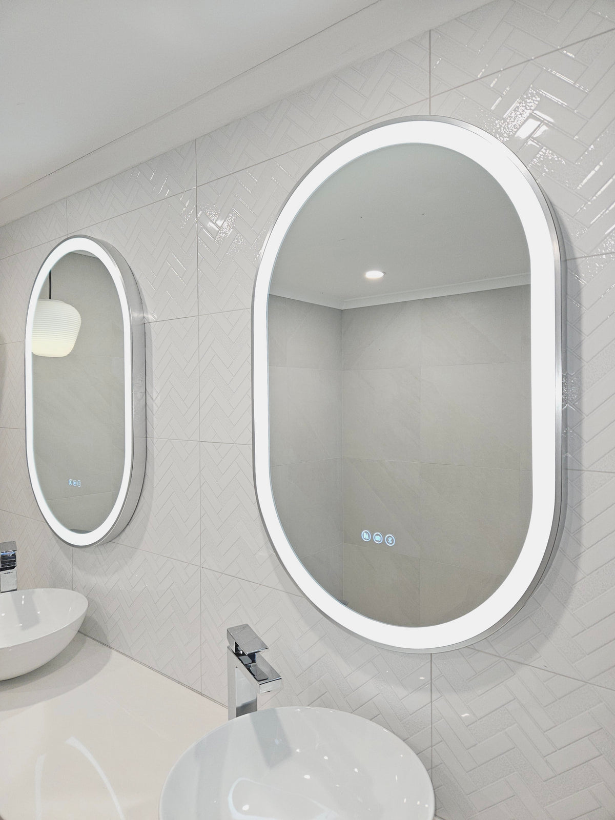 Oval Smart LED Mirrors with Touch Buttons and Silver Frames Elevate Couple's White Bathroom