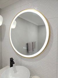 View from Bathroom Door: Gold-Framed Circle-Shaped Smart LED Mirror in White Powder Room