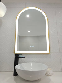 Front View of Gold-Framed Arch-Shaped Mirror in White Powder Room