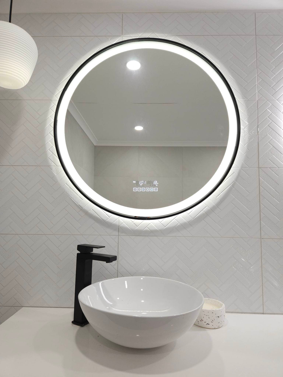 Lighted Black-Framed Circle-Shaped InVogue Smart LED Mirror in White-Themed Powder Room.