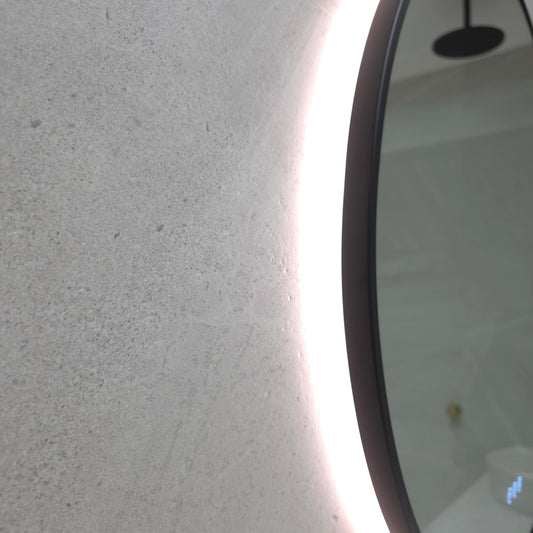 Close-up of the Calais Matte Black frame edge and return lip with the LED glow on the wall