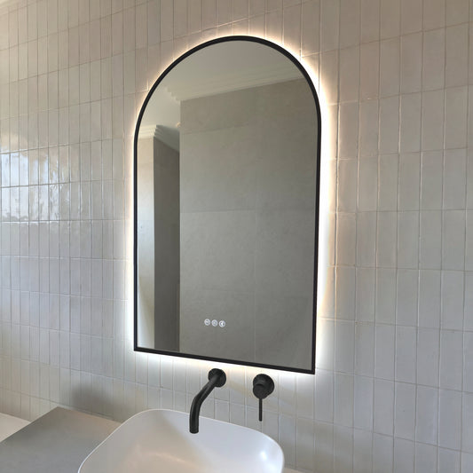 Calais arch-shaped backlit LED mirror in Matte Black above a vessel basin with matching Matte Black tapware