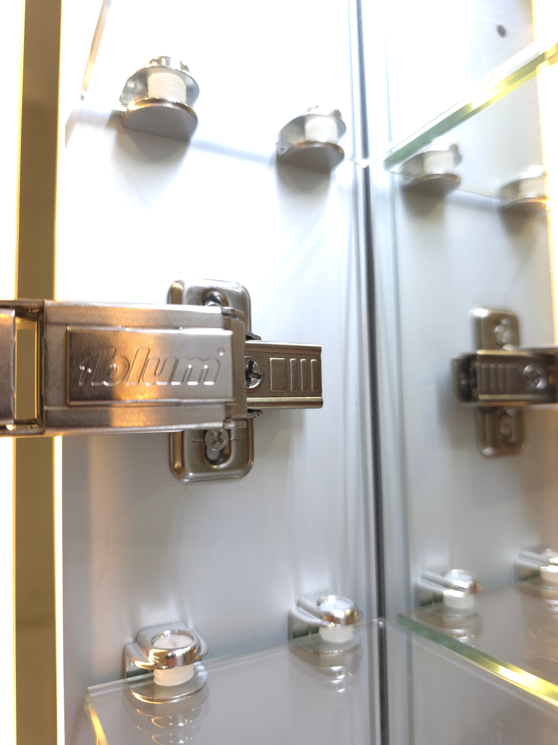 Close up view of Frameless LED mirror cabinet with adjustable glass internal storage shelves and Blum brackets