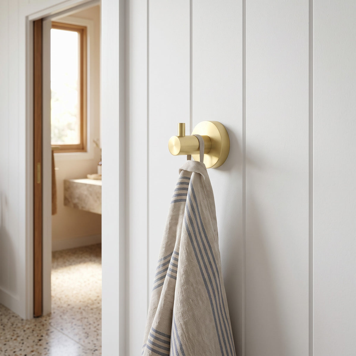 Copenhagen Robe Hook in Brushed Brass in a bathroom