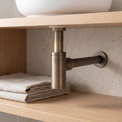 Firenze Basin Bottle Trap in Antique Brass in a bathroom