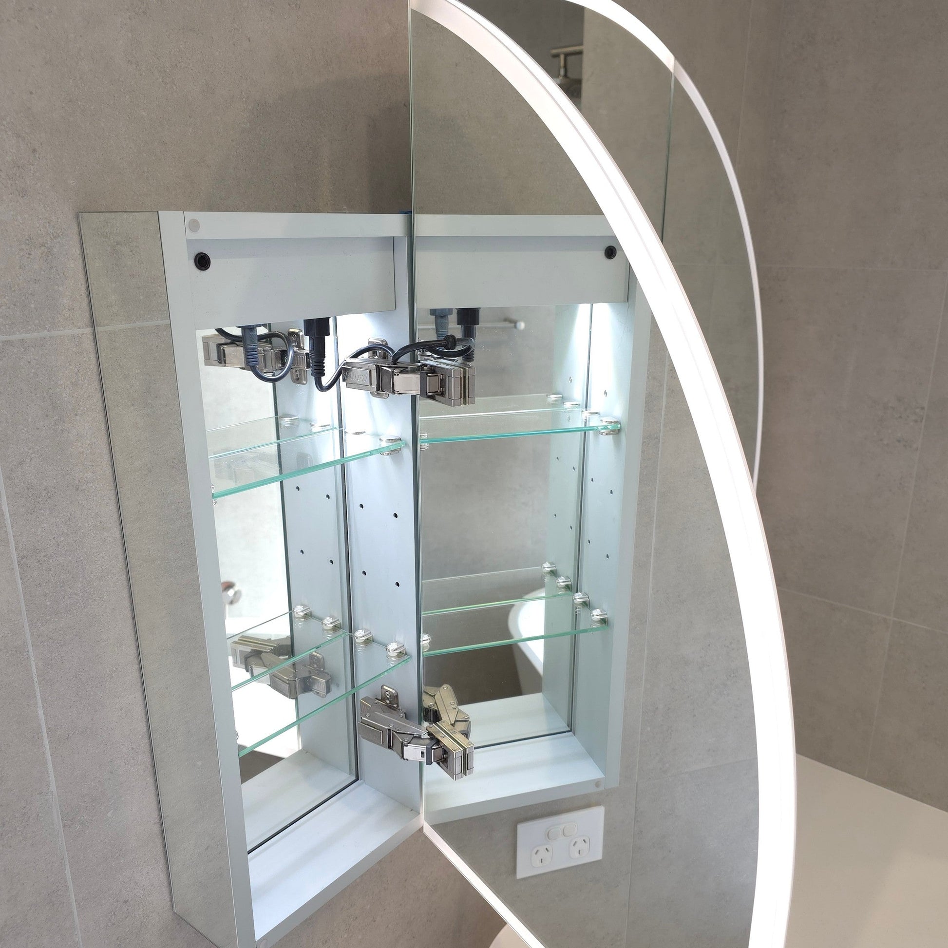 Inside view of frameless LED mirror cabinet with internal storage shelves and sensor light