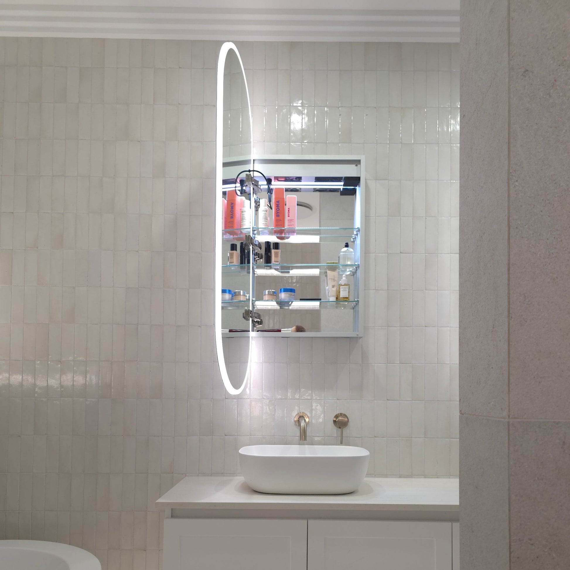 Frameless oval LED mirror cabinet showing internal storage and adjustable glass shelves