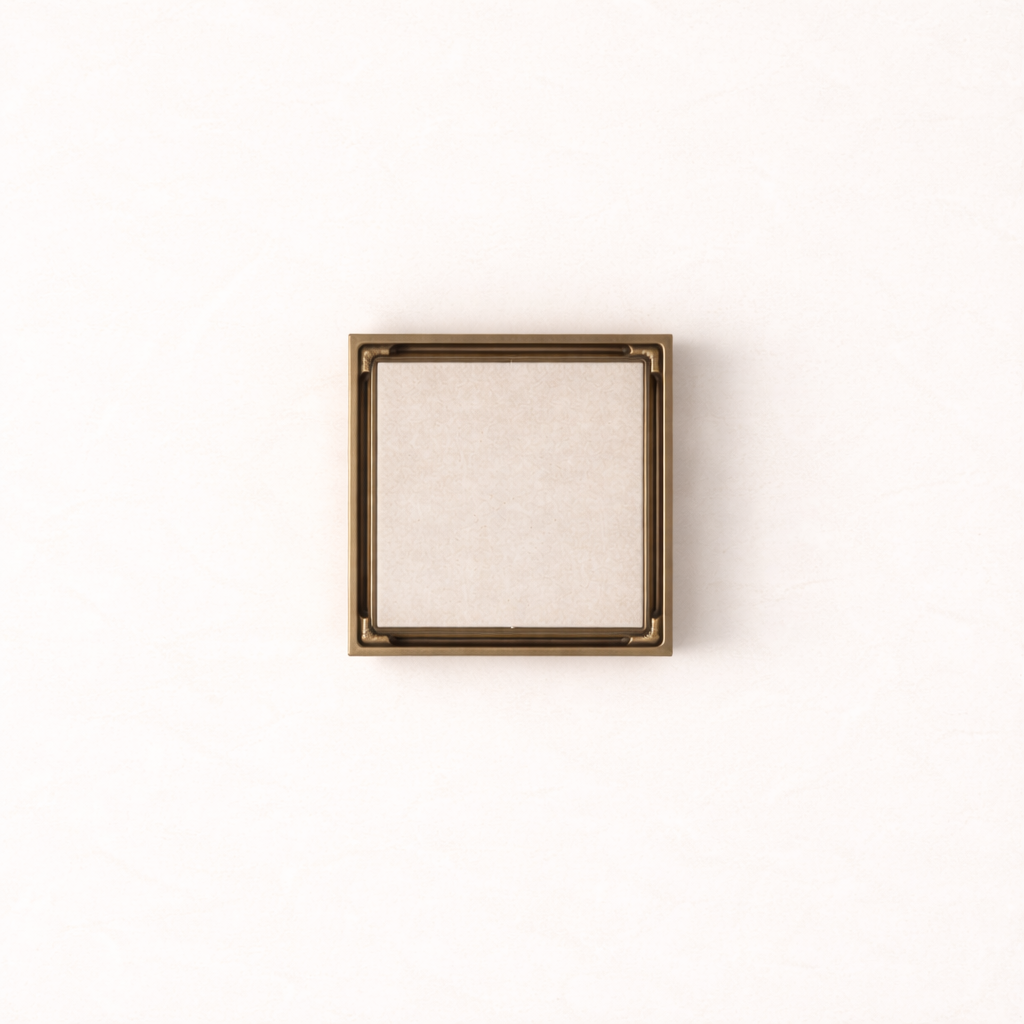 Granada Tile Insert Floor Waste in Antique Brass, top-down view, light stone tile in the cover on a plain white background