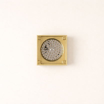 Granada Tile Insert Floor Waste in Brushed Brass, cover removed to show the round strainer on a plain white background