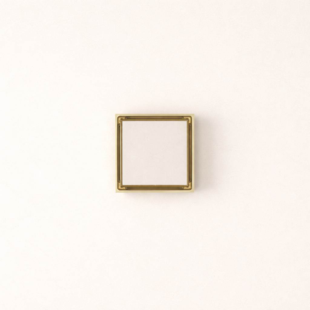 Granada Tile Insert Floor Waste in Brushed Brass, top-down view, light stone tile in the cover on a plain white background