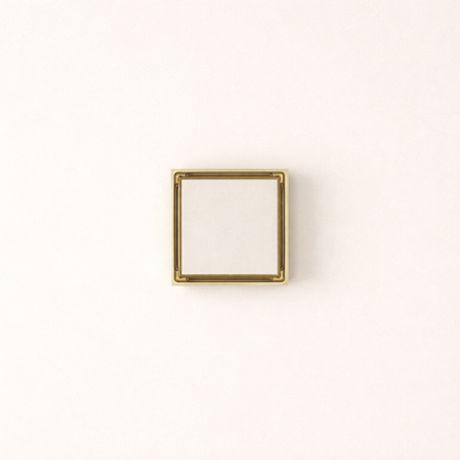 Granada Tile Insert Floor Waste in Brushed Brass, top-down view, light stone tile in the cover on a plain white background
