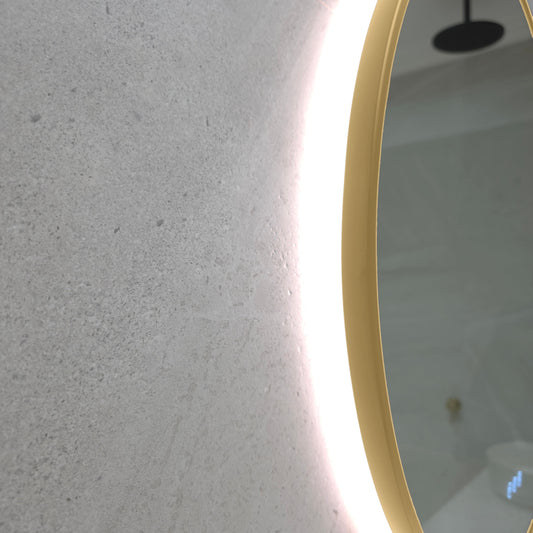 Close-up of the Marseille gold frame edge, which wraps around the glass, with the LED glow on the wall