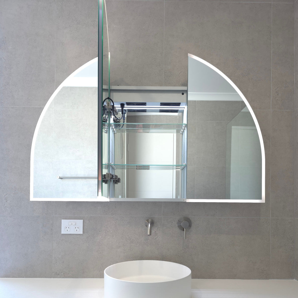 Inside view of arched frameless LED mirror cabinet with internal storage shelves by Invogue