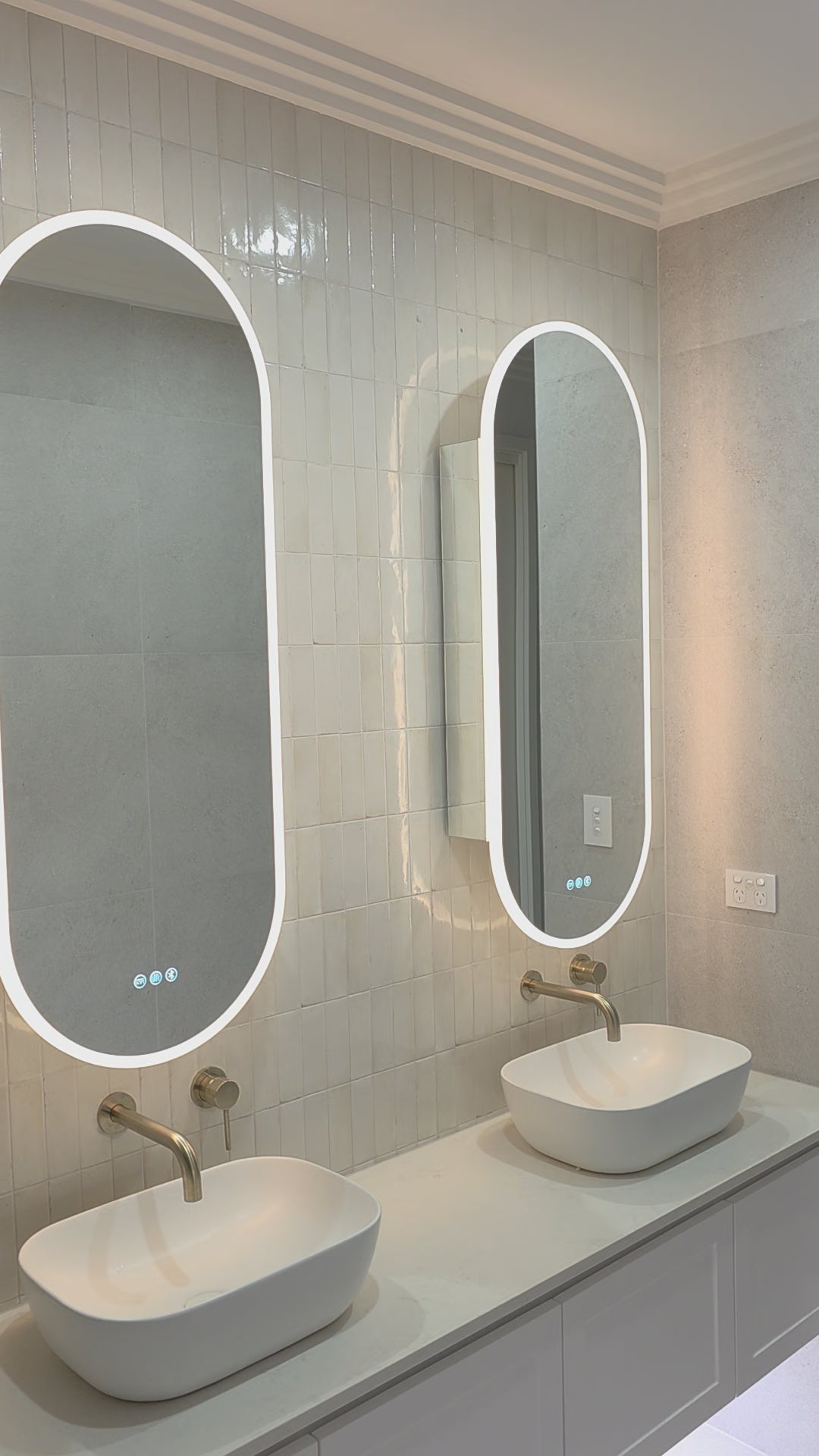 Video of two Riviera Cabinet oval mirror cabinets lit above a double vanity