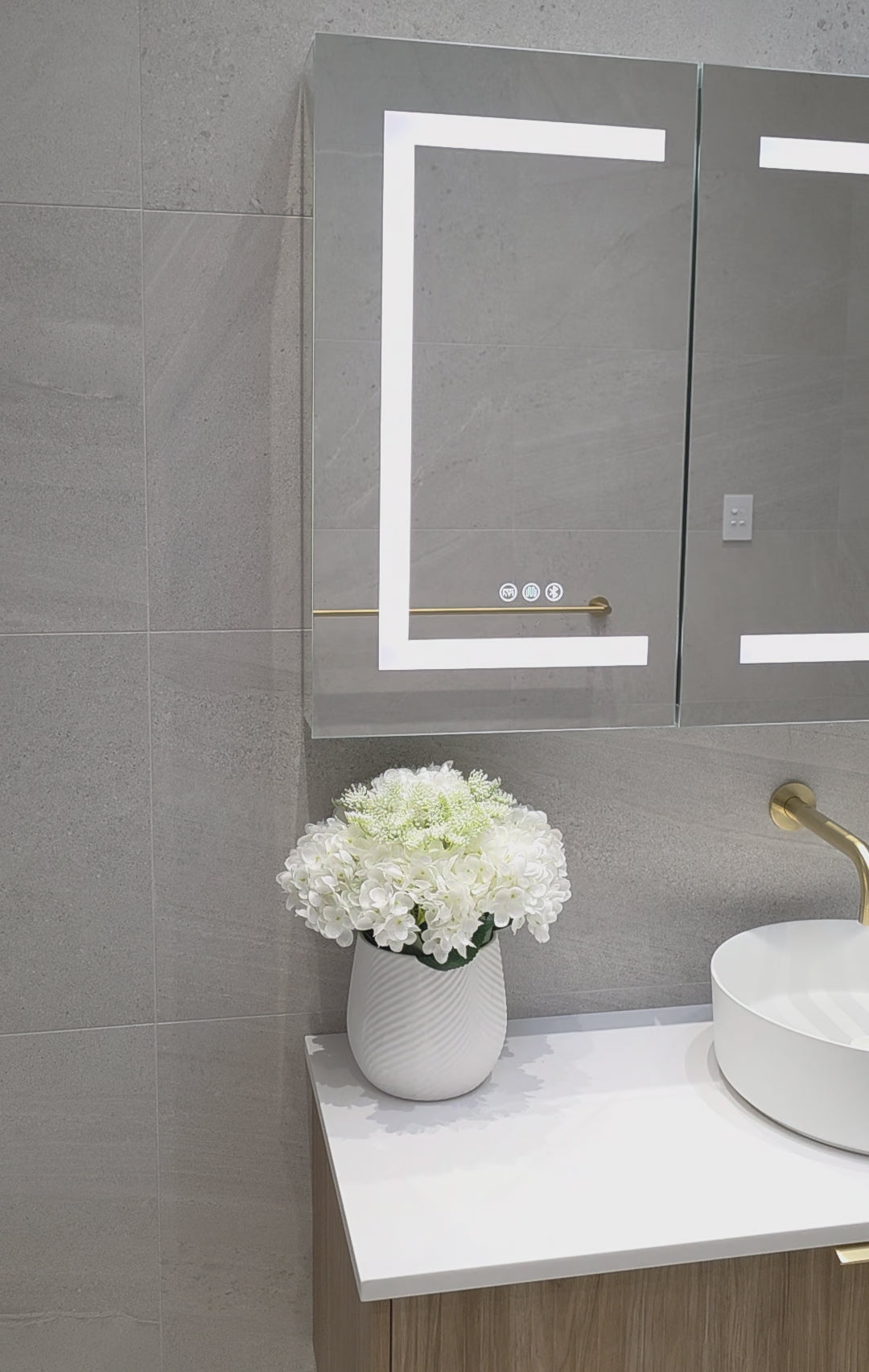 Frameless LED mirror cabinet showing internal storage and lighting