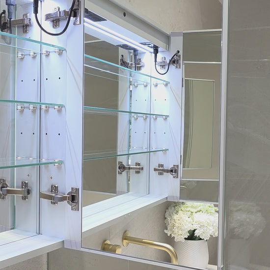 Frameless LED mirror cabinet showing internal storage and adjustable shelves