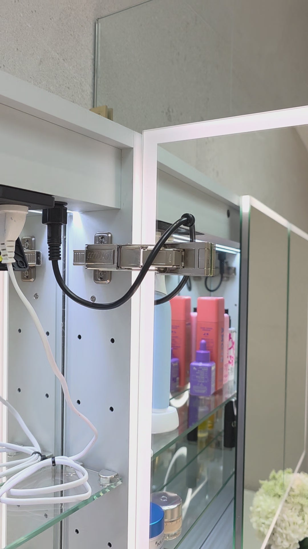 Frameless LED mirror cabinet showing internal glass shelving and lighting