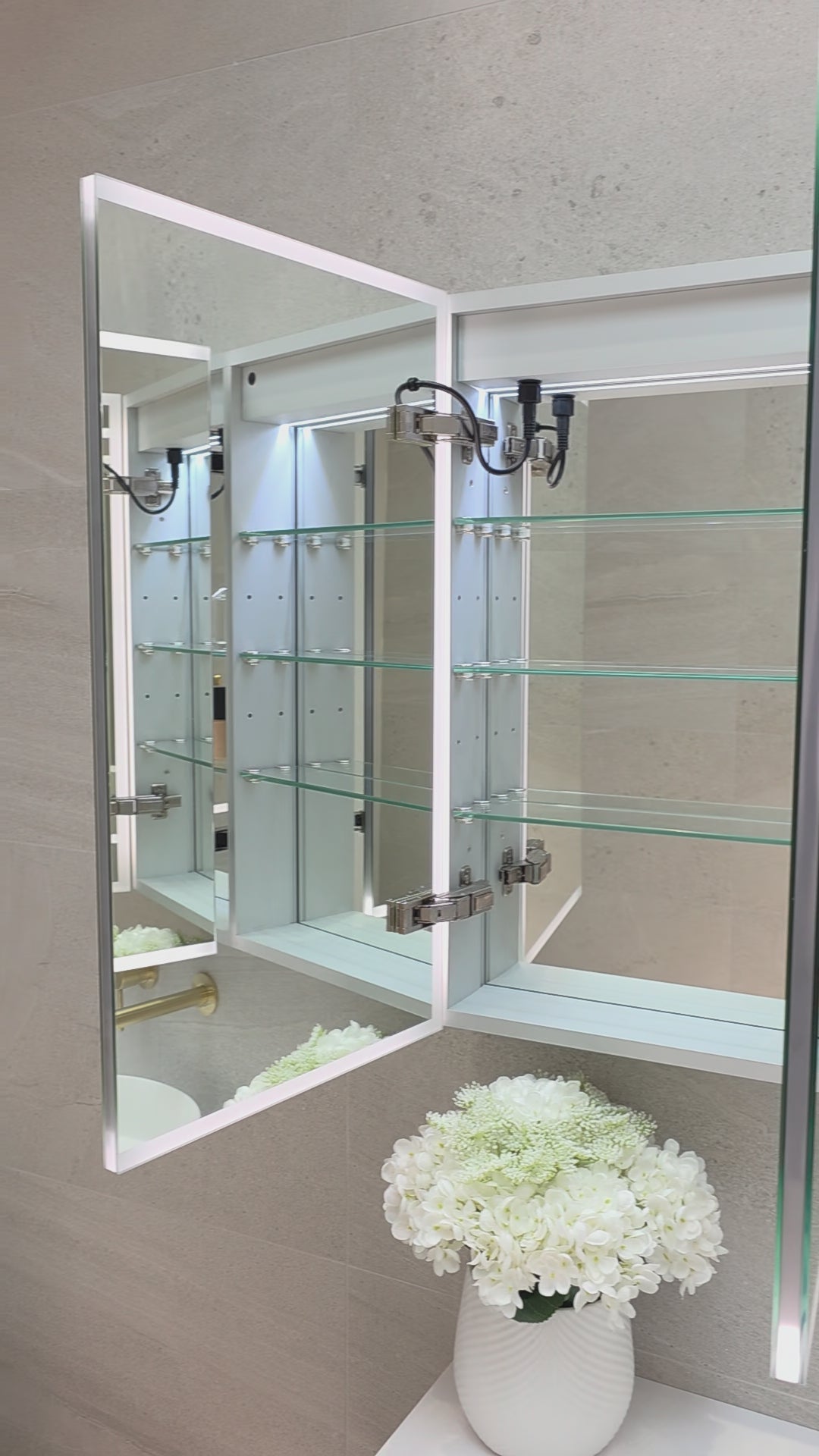 Video demonstration of frameless LED bathroom mirror cabinet showing internal storage and adjustable glass shelves