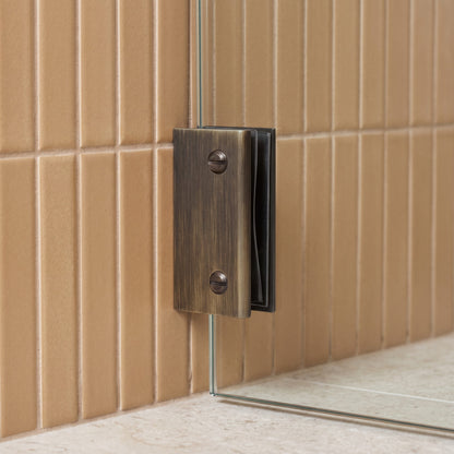Rhodes Shower Glass Clamp in Antique Brass on a glass shower screen