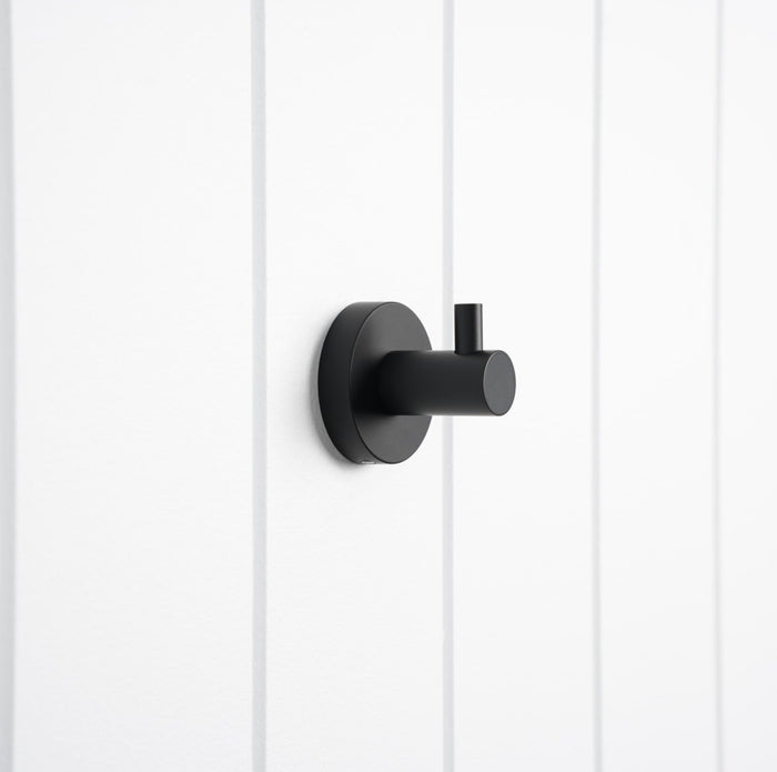 Copenhagen Robe Hook in Matte Black, three-quarter view on a white vertical-panelled wall