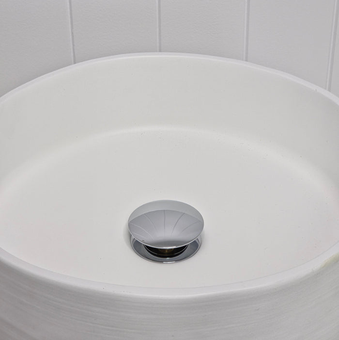 Lisbon Pop Up Basin Waste in Chrome, plug raised open in a round white basin by a white vertical-panelled wall