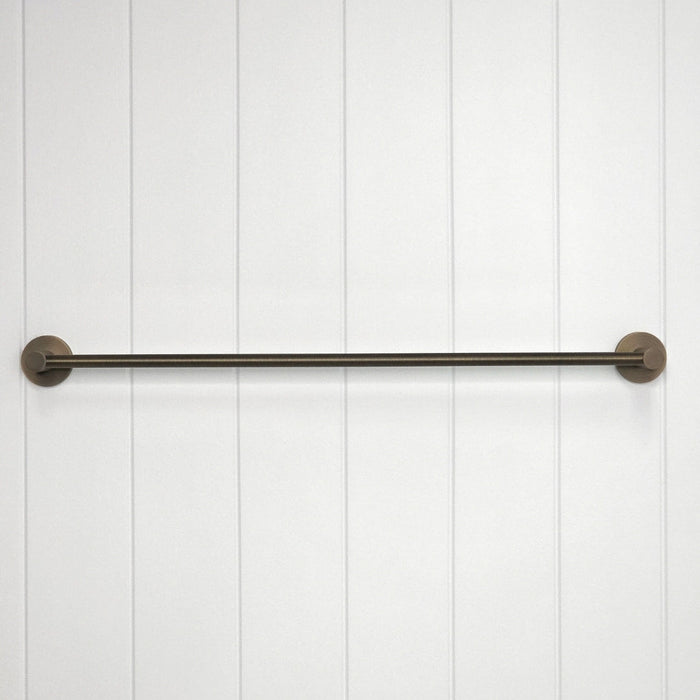 Provence 600mm Single Towel Rail in Antique Brass, front view of the rail and round mounts, white vertical-panelled wall