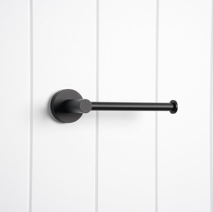 Lille Toilet Roll Holder in Matte Black, three-quarter view, empty, on a white vertical-panelled wall