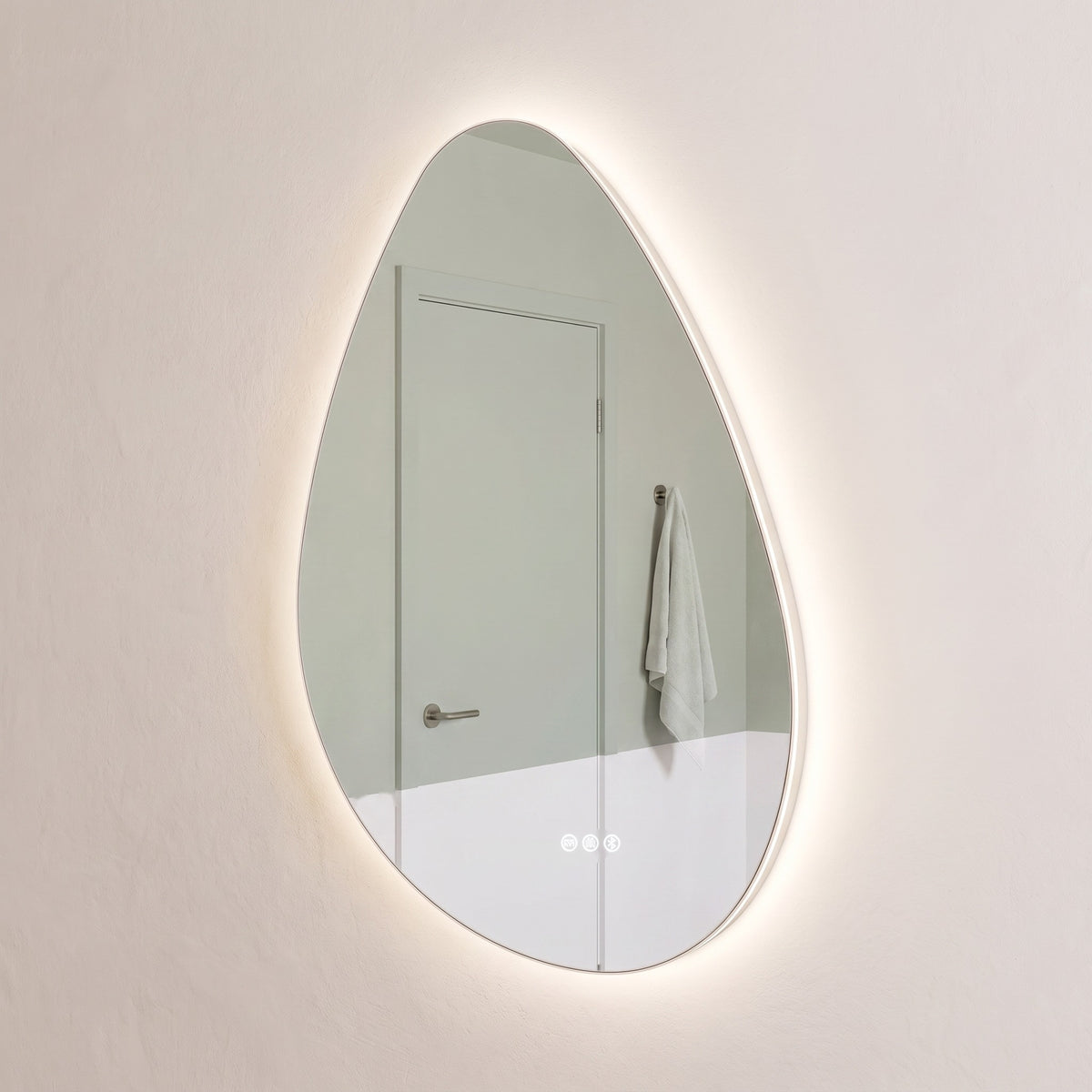 The Sorrento frameless backlit LED mirror hung portrait, angled view showing the slim glass edge floating off the wall