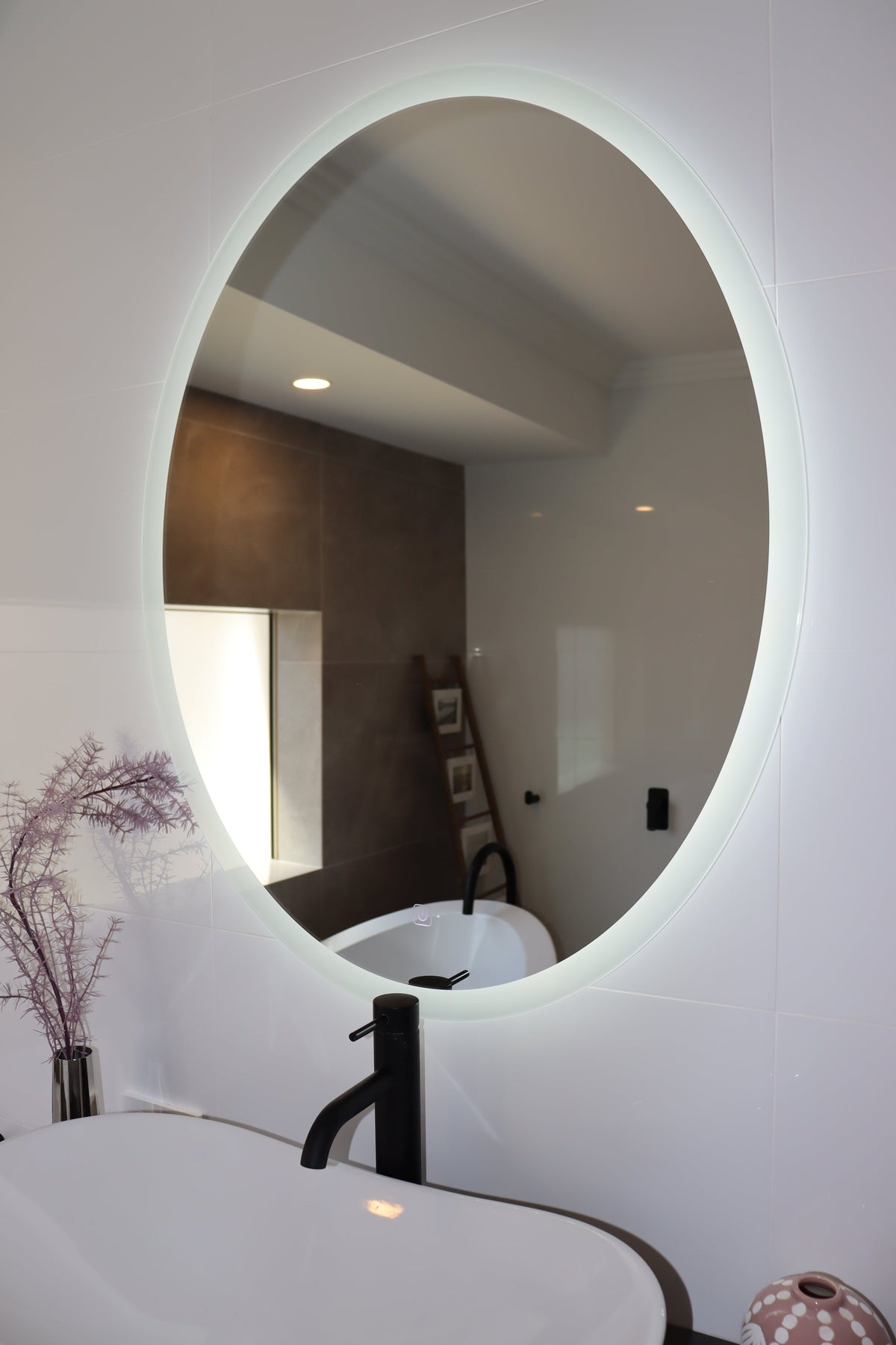  Zoomed-In View of Oval Backlit LED Mirror in Shiny white bathroom