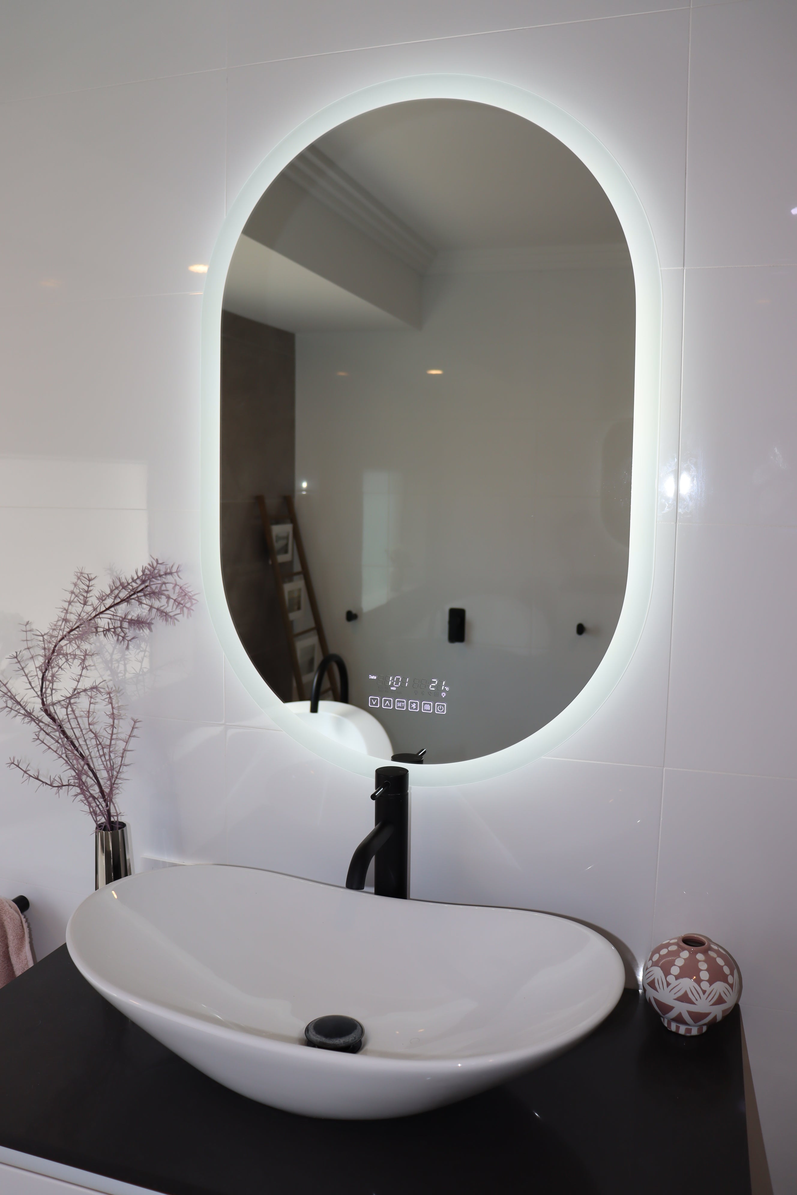 Oval Smart LED mirror with brilliant white backlit LED light and black bathroom countertop