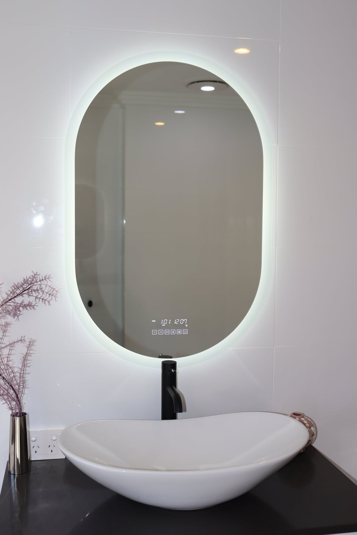  Oval Smart LED mirror above black countertop and white vessel sink