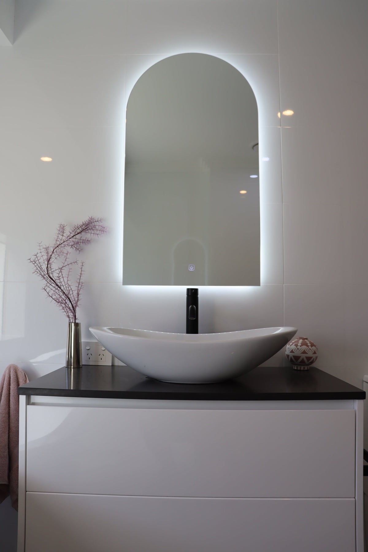 Vanity Space in White Glossy Bathroom with Lighted Arch-Shaped Backlit LED Mirror