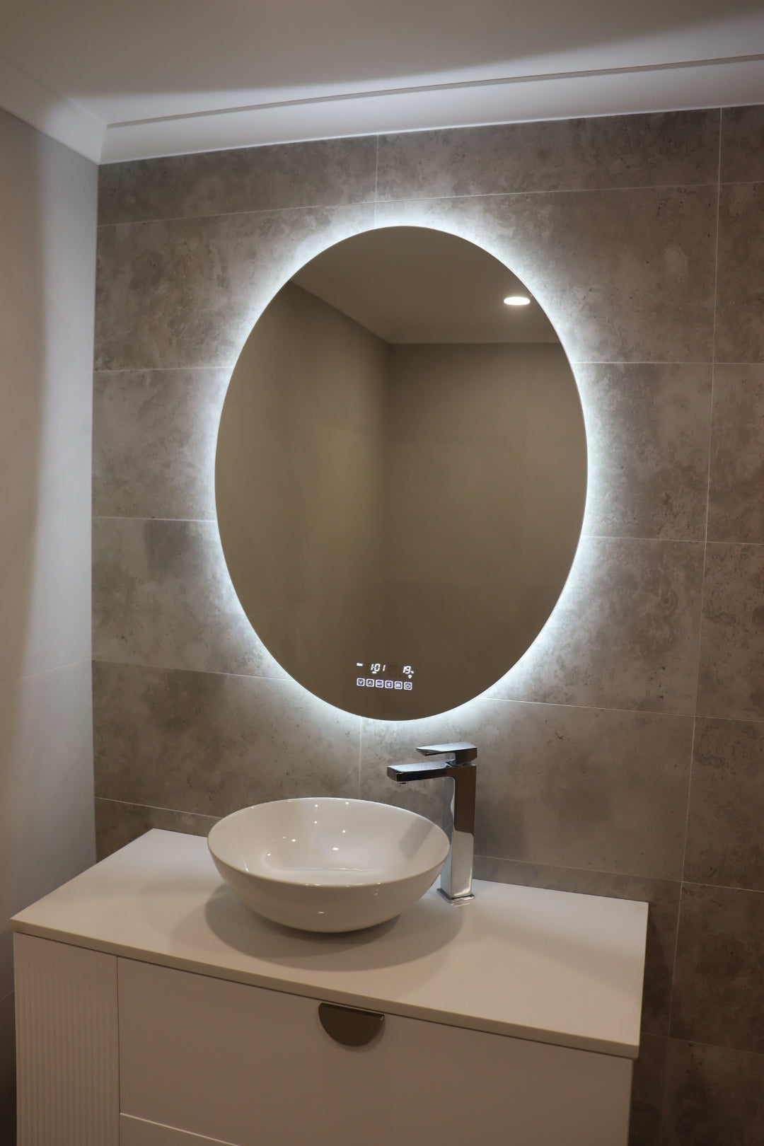 Glowing Elegance of Smart Oval LED Mirror on Greyish Brown Tiles, White Vanity cabinet