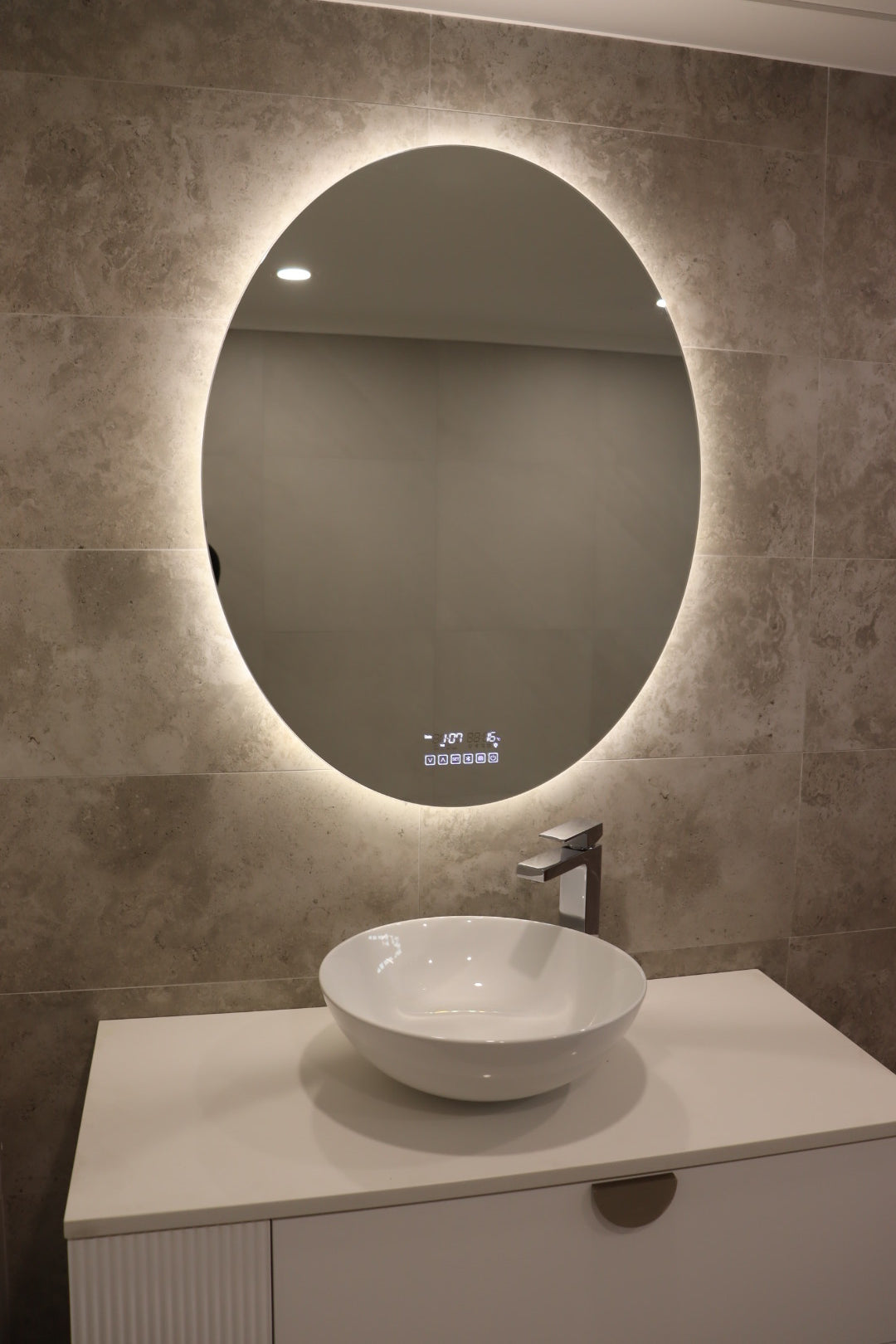 Perfect Look of Oval Smart Backlit LED Mirror on Greyish Brown Tiled Wall and White Floating Cabinet
