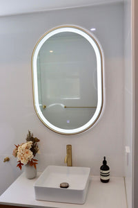 Modern White Bathroom with LED Vanity Mirror, White Sink, Countertop, and Floral Vase